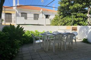 アルトゥーラにあるCasa da Praia - T3 em Alturaのパティオ(テーブル、椅子付)