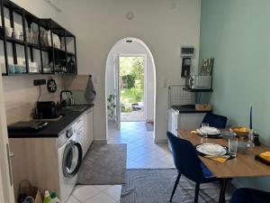 a kitchen with a table and a washing machine at Drop House - One bedroom in Budapest