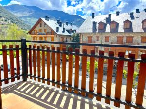 una recinzione in legno con vista su una casa di Apartament lluminós de muntanya by RURAL D'ÀNEU a Esterri d'Àneu