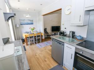 a kitchen and living room with a table in the background at 3 The Barn in Haverfordwest