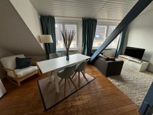 Una sala de estar con una mesa y sillas blancas. en Cosy & central flat near Düsseldorf center, en Düsseldorf