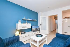 sala de estar con paredes azules y sillas azules en Ferienhaus Bootsmann, en Kellenhusen