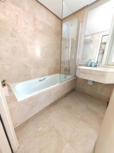 a bathroom with a bath tub and a window at Las Colinas golf resort apartman in Orihuela
