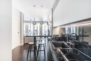 a kitchen with black counter tops and bar stools at Easylife - Milano - Medici 5 P2D - Duomo in Milan