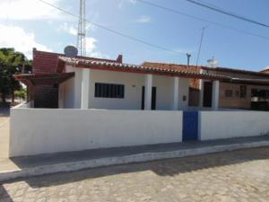 a white house with a white wall at Casa Mobiliada Galinhos in Galinhos