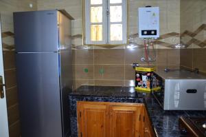 Il comprend une cuisine équipée d'un réfrigérateur en acier inoxydable et une fenêtre. dans l'établissement Apartment Medina Fes, à Fès 17 autres photos