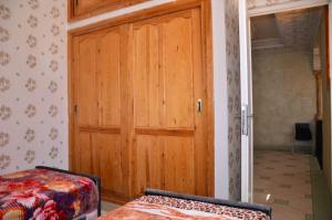 - une porte en bois dans une chambre avec un lit dans l'établissement Apartment Medina Fes, à Fès