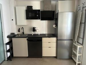 a small kitchen with a refrigerator and a sink at Apto 2.Duplex con jardin.Centrico- in Villanueva de la Cañada