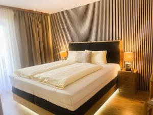 a bedroom with a large bed with two lamps on it at Gästehaus -Pension Edelweiss in Vent