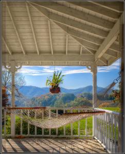 a hammock on a porch with a view of the mountains at Blue Mountain Mist Country Inn in Pigeon Forge