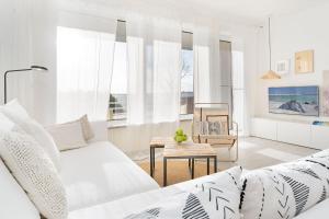 a white living room with a couch and a table at Auszeit am Meer in Lemkenhafen auf Fehmarn