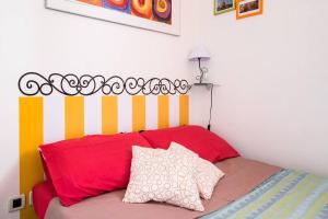 1 dormitorio con cama roja y cabecero a rayas en BellaBo Apartment, en Bolonia