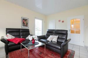 un salon avec un canapé en cuir et une table dans l'établissement Haus Seestern Grömitz Strandglück, à Grömitz