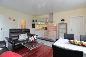 un salon avec un canapé et une table dans l'établissement Haus Seestern Grömitz Strandglück, à Grömitz