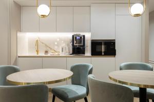 a room with two tables and chairs and a kitchen at Alojamento da Vila Golden in Valença