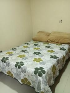 a bed with a blanket with flowers on it at hostel da tia EDA in Rio de Janeiro