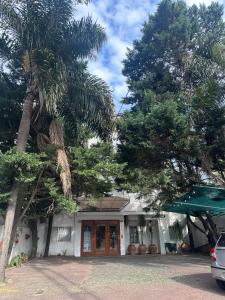 a house with a palm tree in front of it at Apart Bosch House in Vicente López