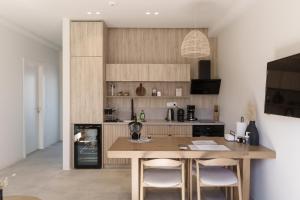 a kitchen with a wooden table with two chairs at Poema Antiparos in Antiparos
