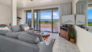 ein Wohnzimmer mit Couch und Fernseher mit Aussicht in der Unterkunft Kapalua Golf Villa 23V3 in Kapalua