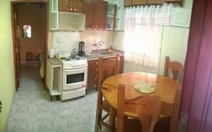 cocina con mesa y horno de fogón blanco en Apart Ma & Cris en Termas de Río Hondo