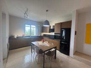 a kitchen with a table and chairs and a black refrigerator at Privat Pool Garden Villa in Gjilek