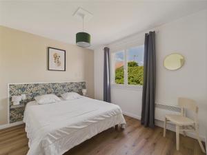 ein Schlafzimmer mit einem Bett und einem Fenster in der Unterkunft Maison de vacances à Saint Hilaire de Riez in Saint-Hilaire-de-Riez