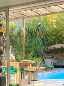 a patio with a table and chairs next to a pool at Maison d hôtes LA VILLA MADELEINE in Sanary-sur-Mer