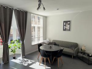 a living room with a table and a couch at EMM Guesthouse in Ieper