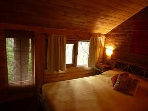 a bedroom with a large bed in a wooden room at Cabaña Kultrum Mar Azul in Mar Azul
