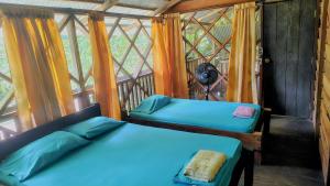 zwei Betten in einem Zimmer mit Fenster in der Unterkunft Paraíso Ayahuasca Hotel & Tours in Puerto Nariño