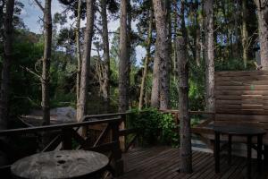 a wooden deck with a bench and a table at Cabaña Kultrum Mar Azul in Mar Azul