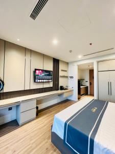a bedroom with a bed and a desk with a tv at Flamingo Hải Tiến - IBIZA - Phòng 526 và 724 in Thanh Hóa