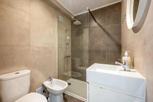 a bathroom with a toilet and a sink and a shower at GuestReady - Seaview in Costa da Caparica in Costa da Caparica +22 photos