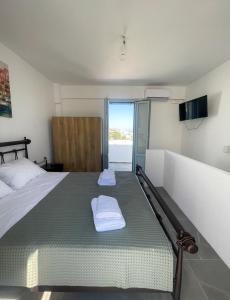 a bedroom with a bed with two pillows on it at Aliki's Apartments in Vóthon +23 photos