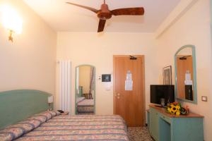 a bedroom with a bed and a ceiling fan at Hotel Magnolia in Albenga +50 photos