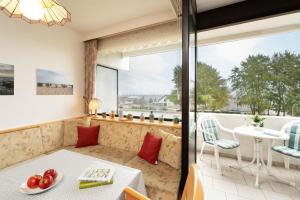 a room with a table and chairs and a large window at Haus Vier Jahreszeiten Wellenblick in Dahme