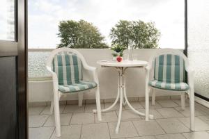 two chairs and a table on a balcony at Haus Vier Jahreszeiten Wellenblick in Dahme