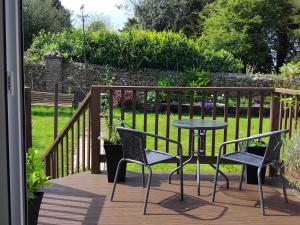 a patio with a table and chairs on a deck at The Garden Room at Dartmouth in Dartmouth +6 photos