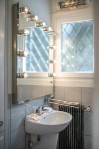 a bathroom with a sink and a mirror and a window at Le Coq Saint-Jean - Parking - WiFi - Reposant in Gorbio +32 photos