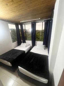due letti in una stanza con finestra di Apartamento Sur De Cali Santa Anita Excelente Ubicación a Cali