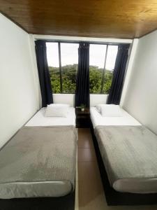 due letti in una piccola stanza con una finestra di Apartamento Sur De Cali Santa Anita Excelente Ubicación a Cali