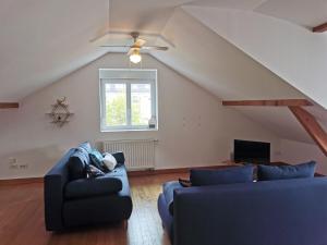 a living room with two blue couches and a window at Le Bretzel in Zillisheim