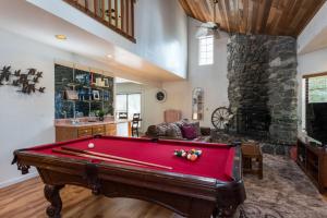 a pool table in a living room with a stone fireplace at Inside Yosemite Mountain Beauty in Yosemite West