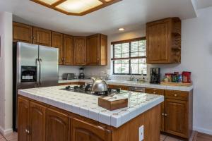 a kitchen with wooden cabinets and a stainless steel refrigerator at Inside Yosemite Mountain Beauty in Yosemite West