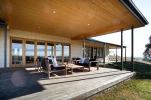 a porch of a house with chairs and windows at Drom Aluinn B & B in Acheron