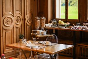 a dining room with a table and a counter with dishes at Le Manoir du Golf in Publier