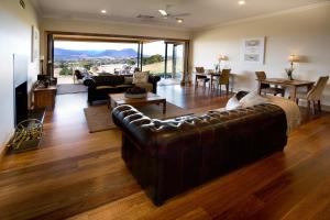 a large living room with a leather couch and a dining room at Drom Aluinn B & B in Acheron