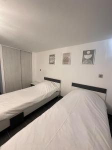 two beds in a room with white walls at Vivre Sainte-Maxime à pieds in Sainte-Maxime +29 photos