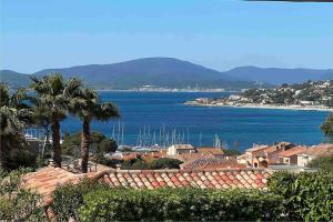 a view of a city and the ocean with palm trees at Vivre Sainte-Maxime à pieds in Sainte-Maxime