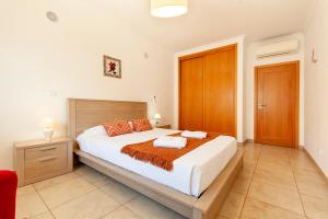 a bedroom with a large bed and a red chair at Luxury 1 Bed Fully Equipped with Pool in Lagos +63 photos